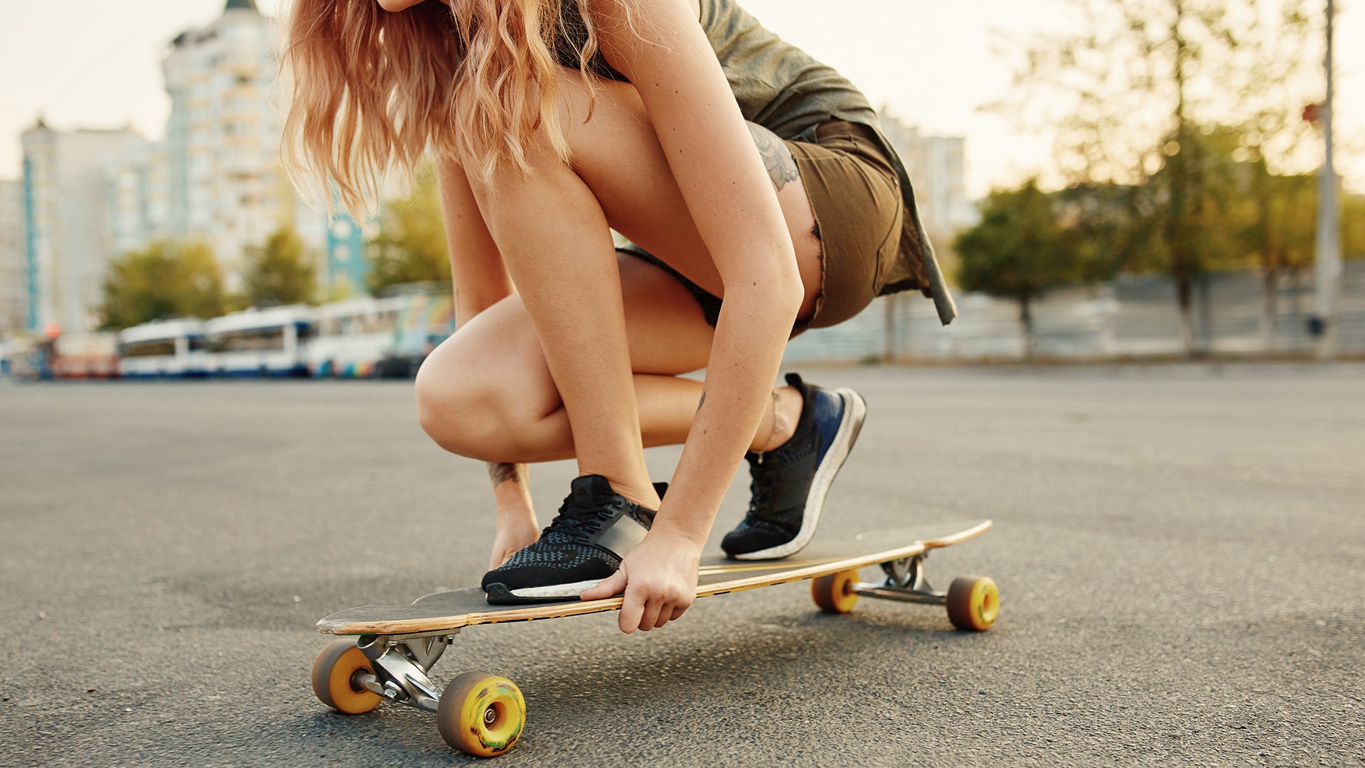 A lady is seating on her skateboard